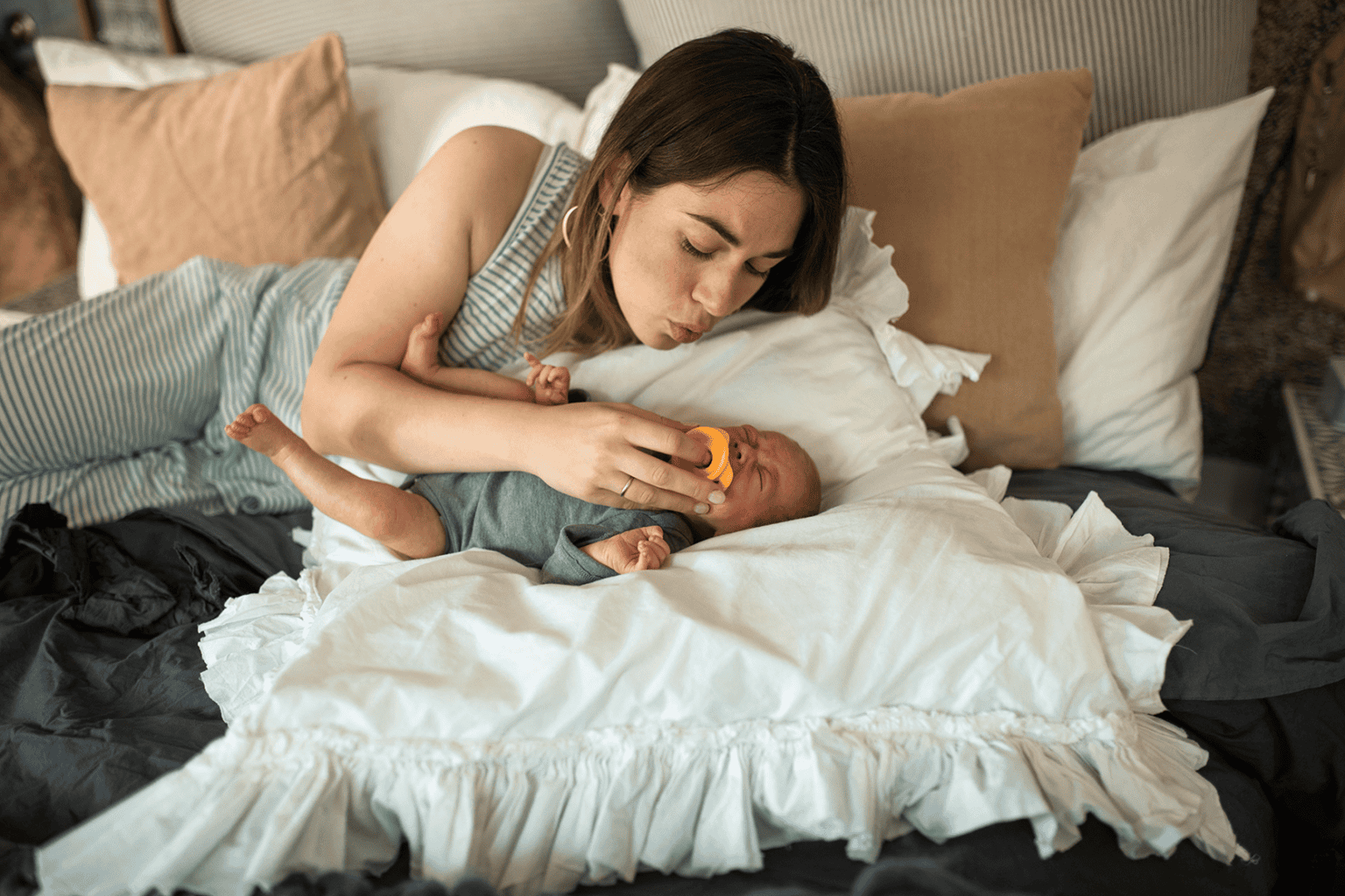A mom taking care of her newborn and herself during postpartum recovery.