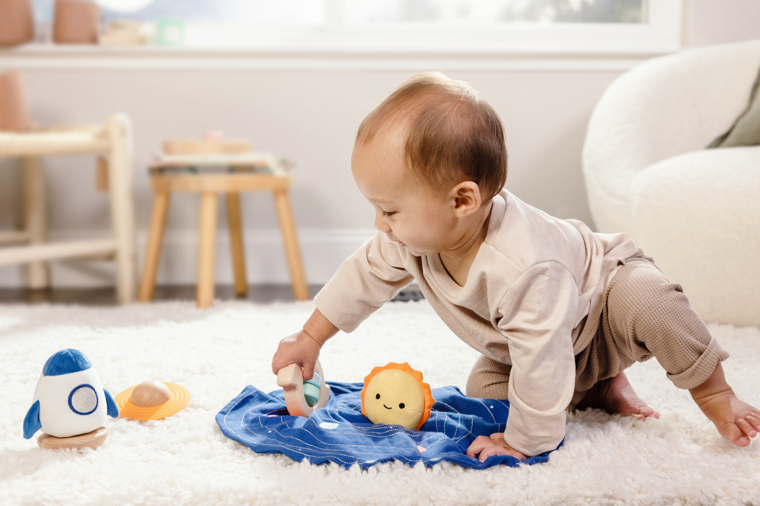 A baby playing with a plush solar system set.