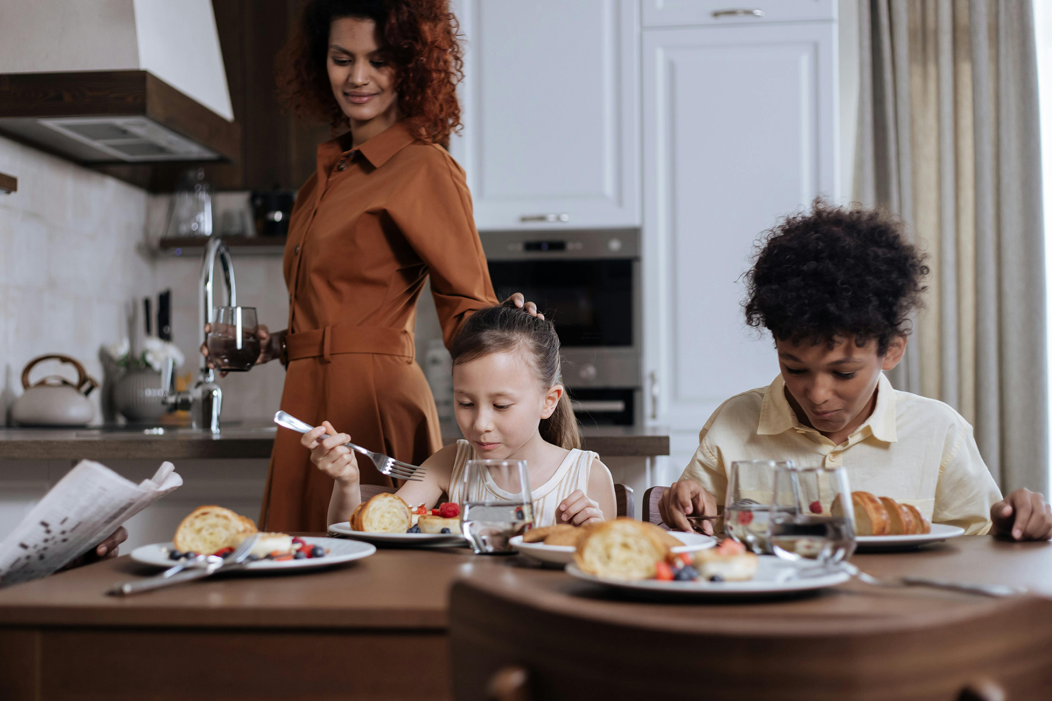 Family mindfully eating breakfast at the dining table.