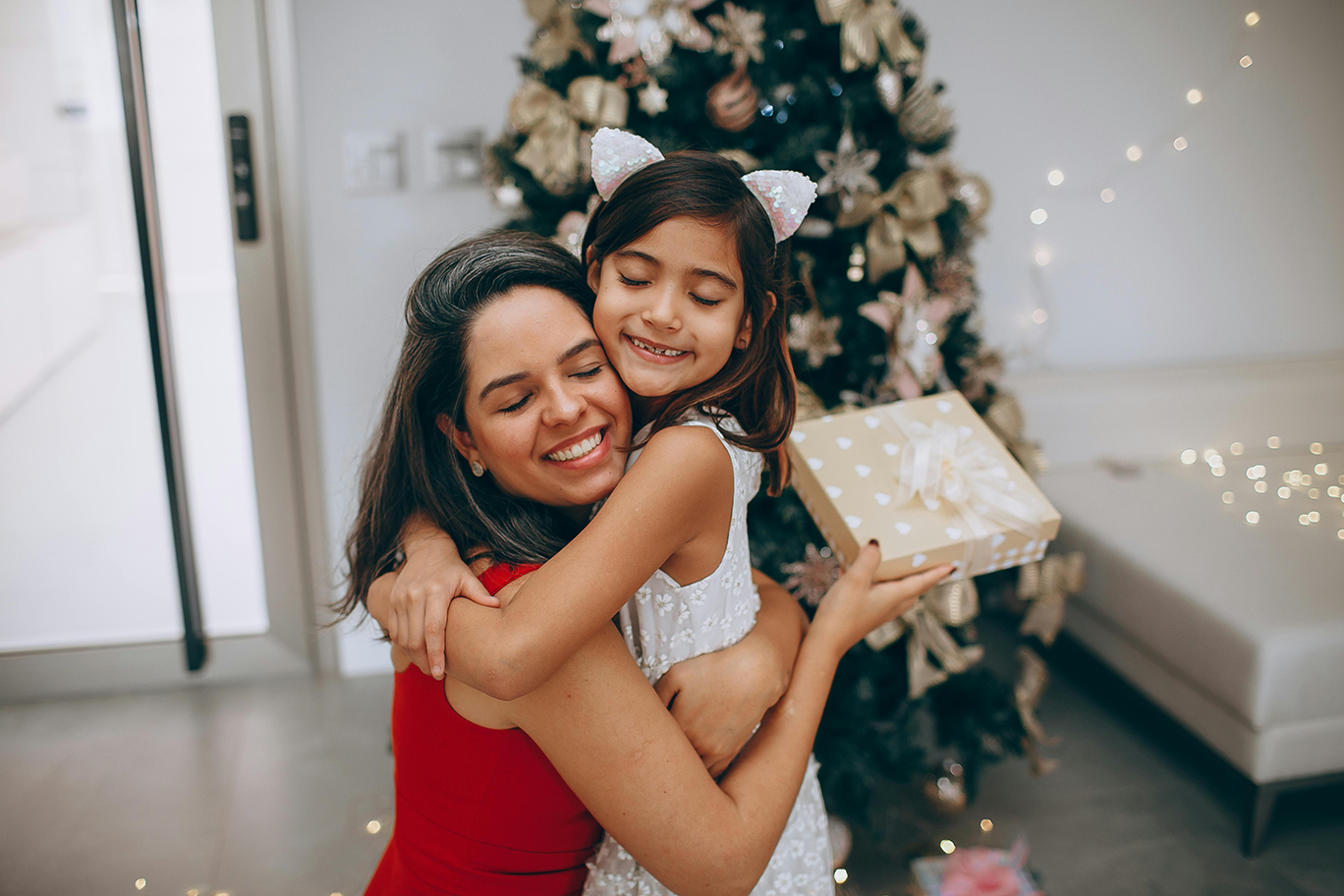 A mother and daughter hugging after giving Mom a gift.