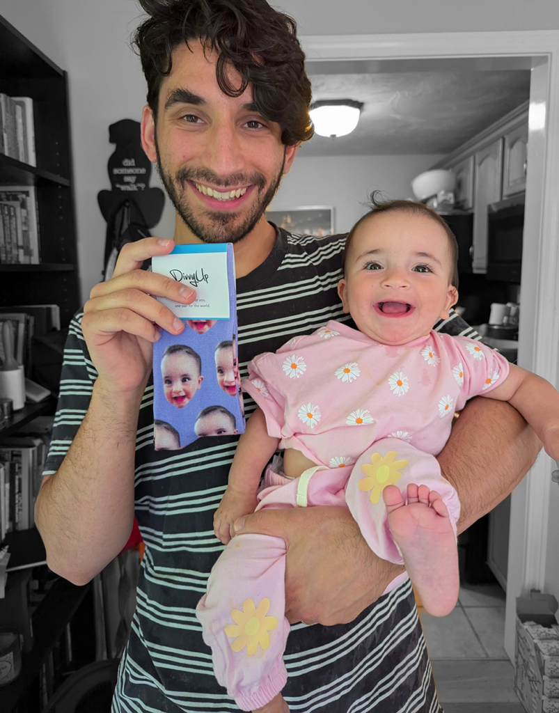 A father holding customized socks.
