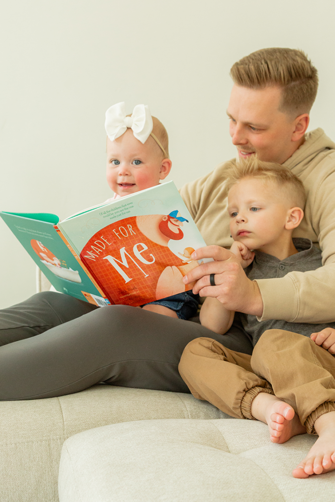 A father reading the book Made for Me to his two kids.