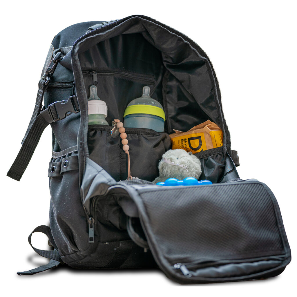 A diaper backpack unzipped to show baby bottles, wipes, and more.