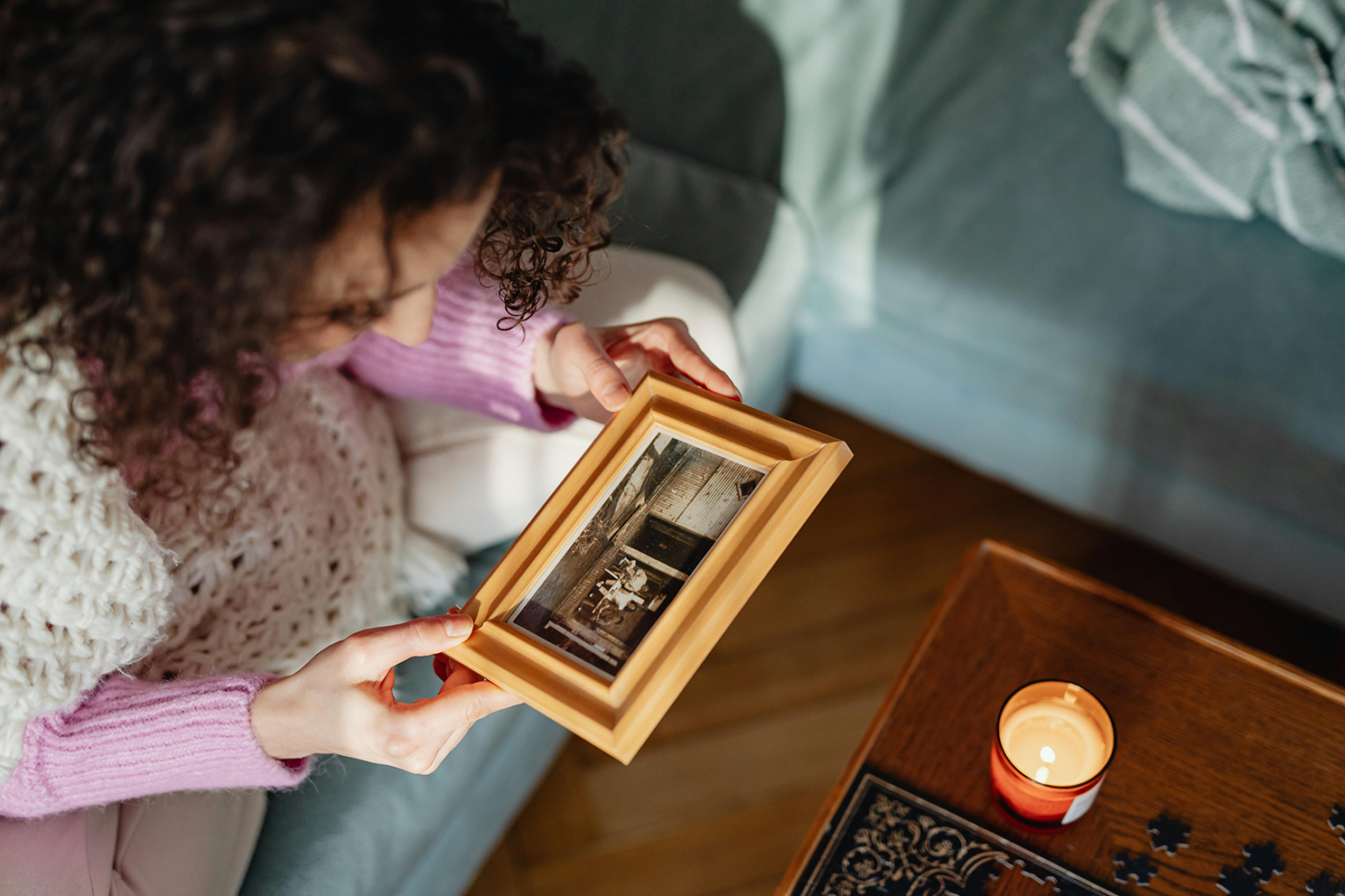 Woman looking at a picture in a wooden picture frame.