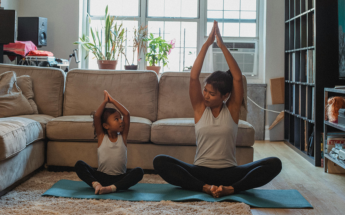 A mom and daughter doing yoga together.