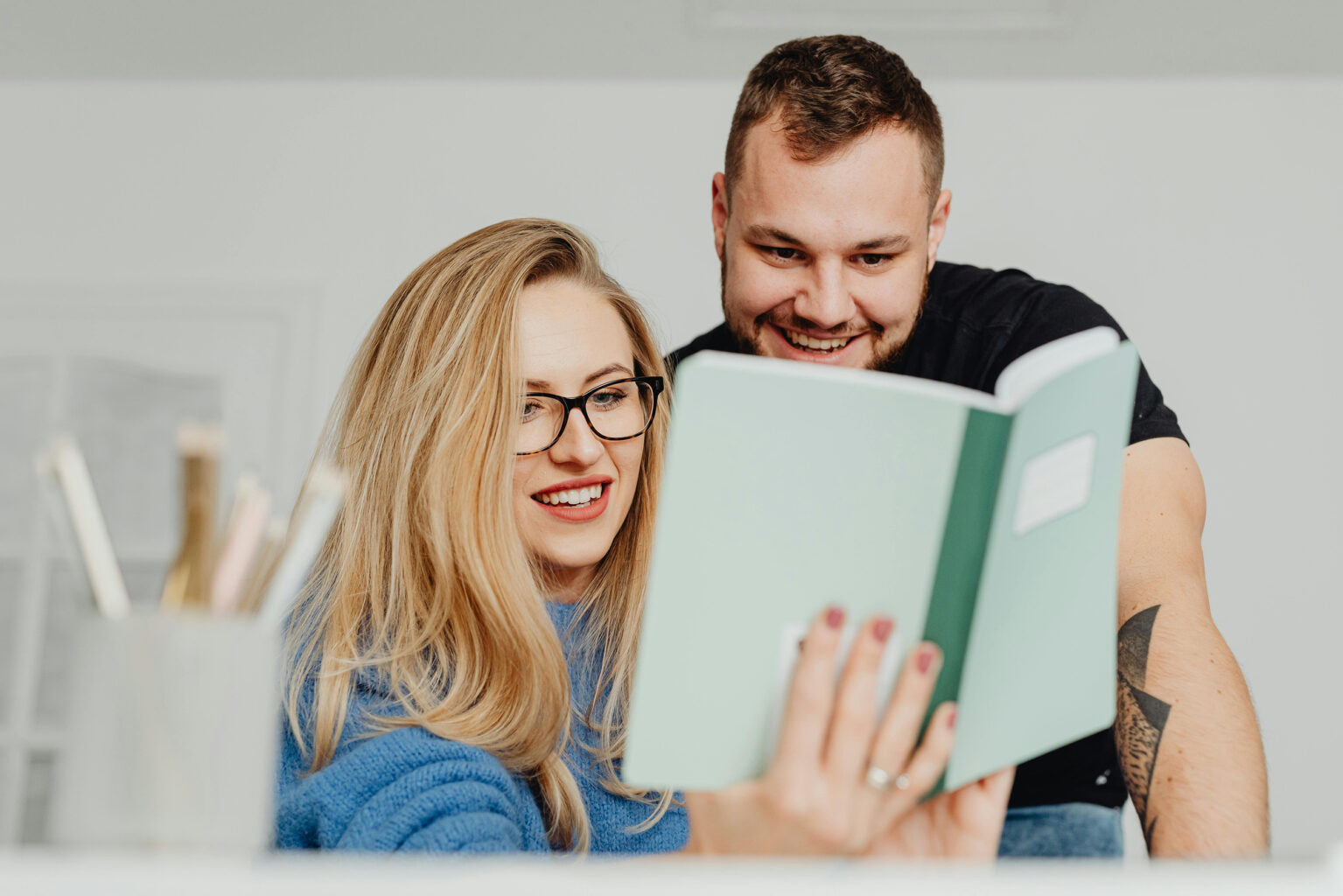 A young couple looking at a journal together.
