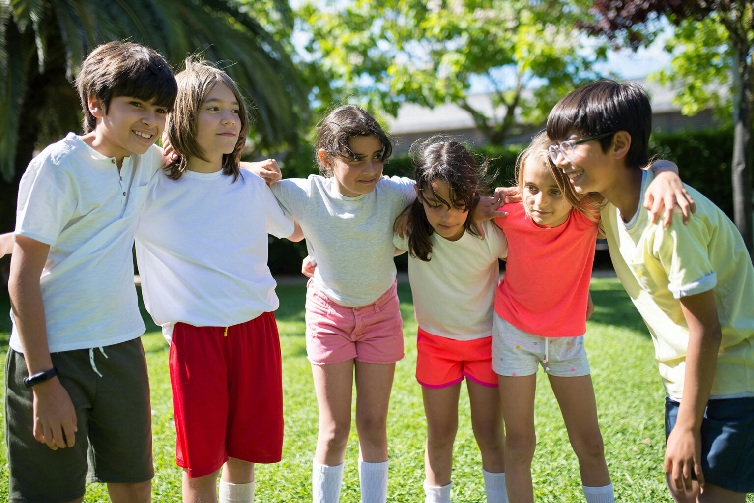 A group of friends with their arms around each other’s shoulders.