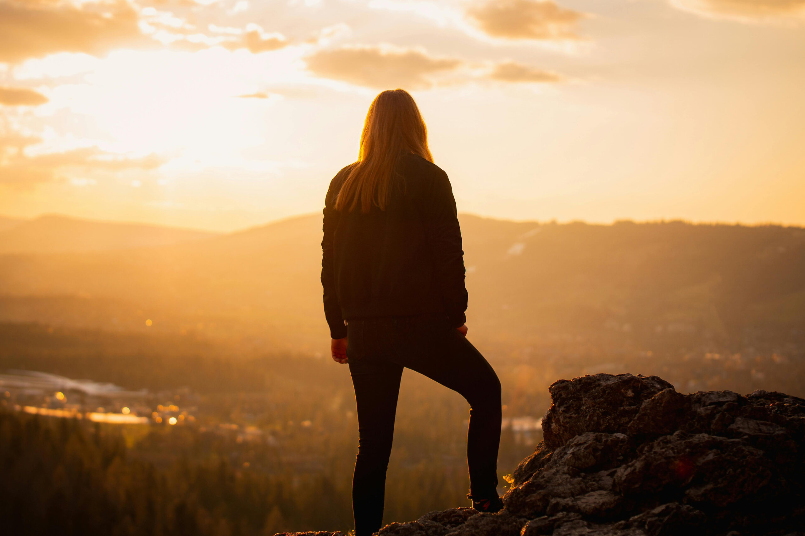 A woman watching the sunrise in the mountains.