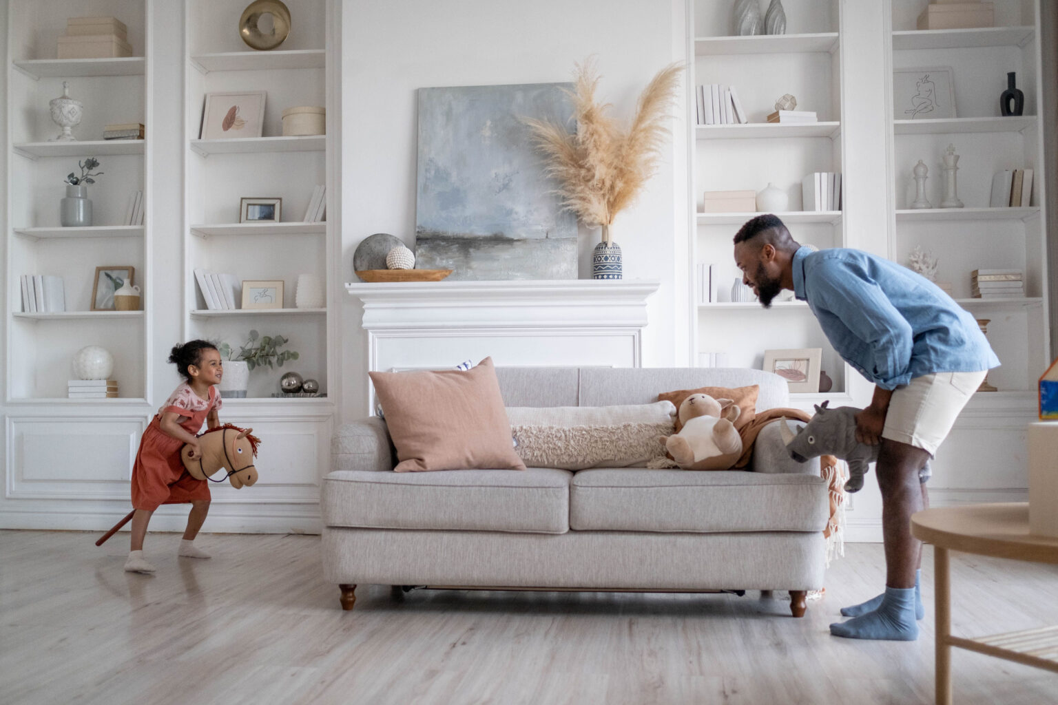 A father and child playing together next to a couch