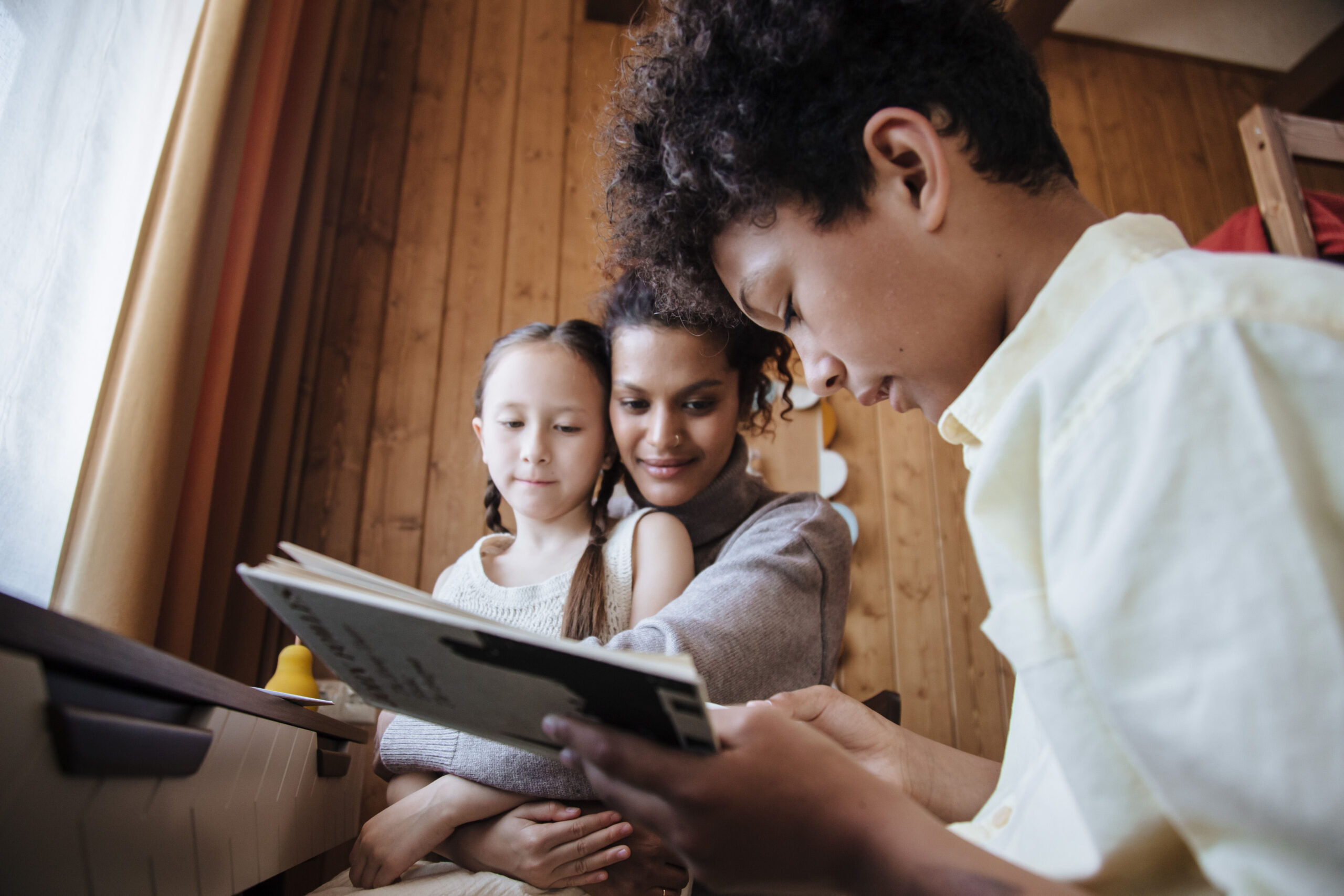 A mother, son and daughter reading together