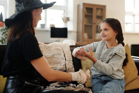 Mother and daughter putting together a DIY Halloween costume on a couch