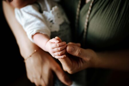 A baby holding a mom's hand